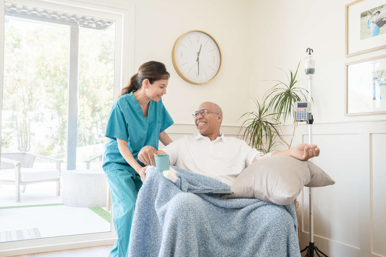 Nurse assisting patient receiving IVIG at home