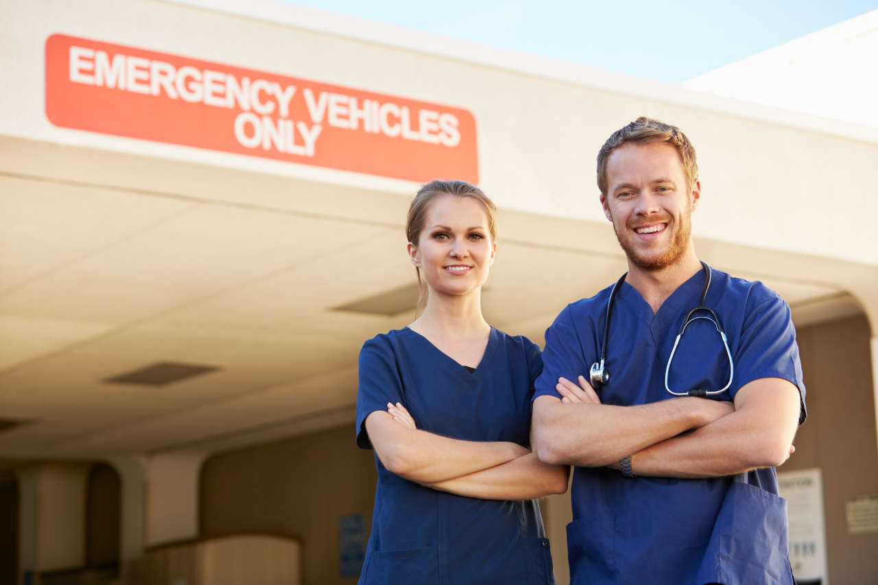 ER Nurses, one of the specialties most in-demand, standing in front of hospital building.